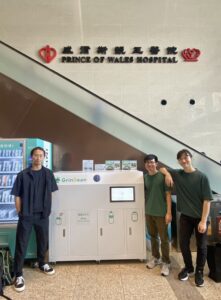3個人站在機器前面，背景為醫院的招牌